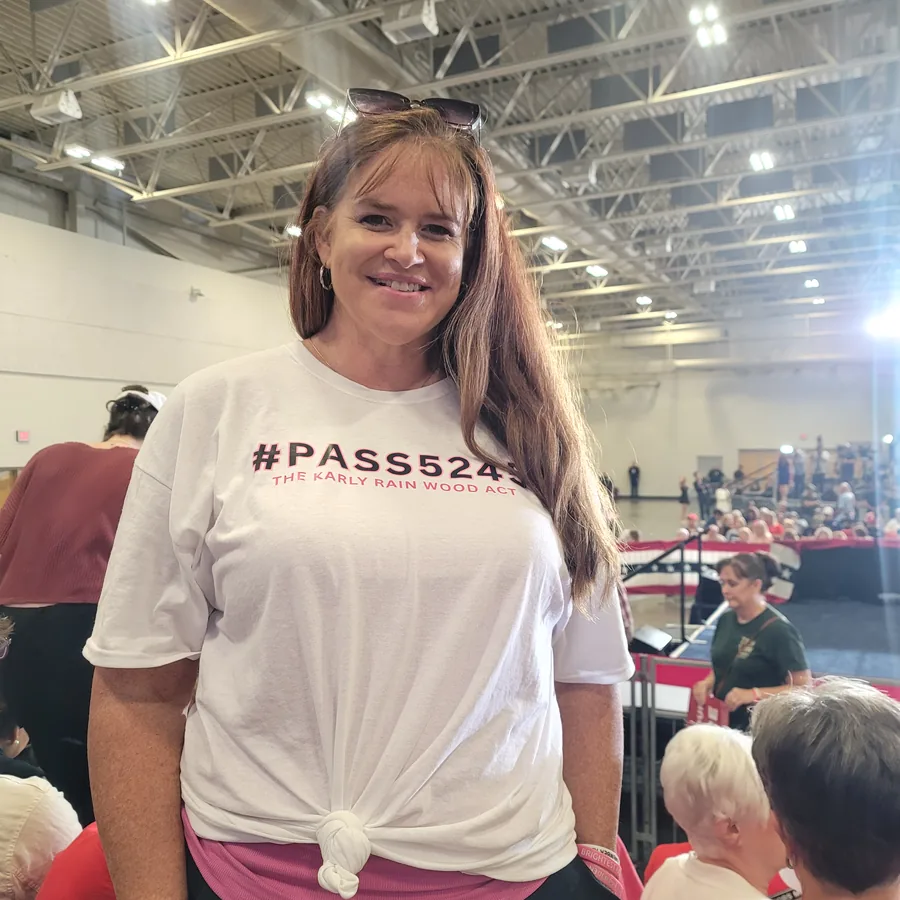 Amber Wood wearing a #PASS5245 The Karly Rain Wood Act shirt at a public event.